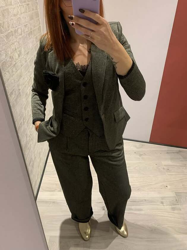 Femme en costume gris avec gilet et bottes dorées